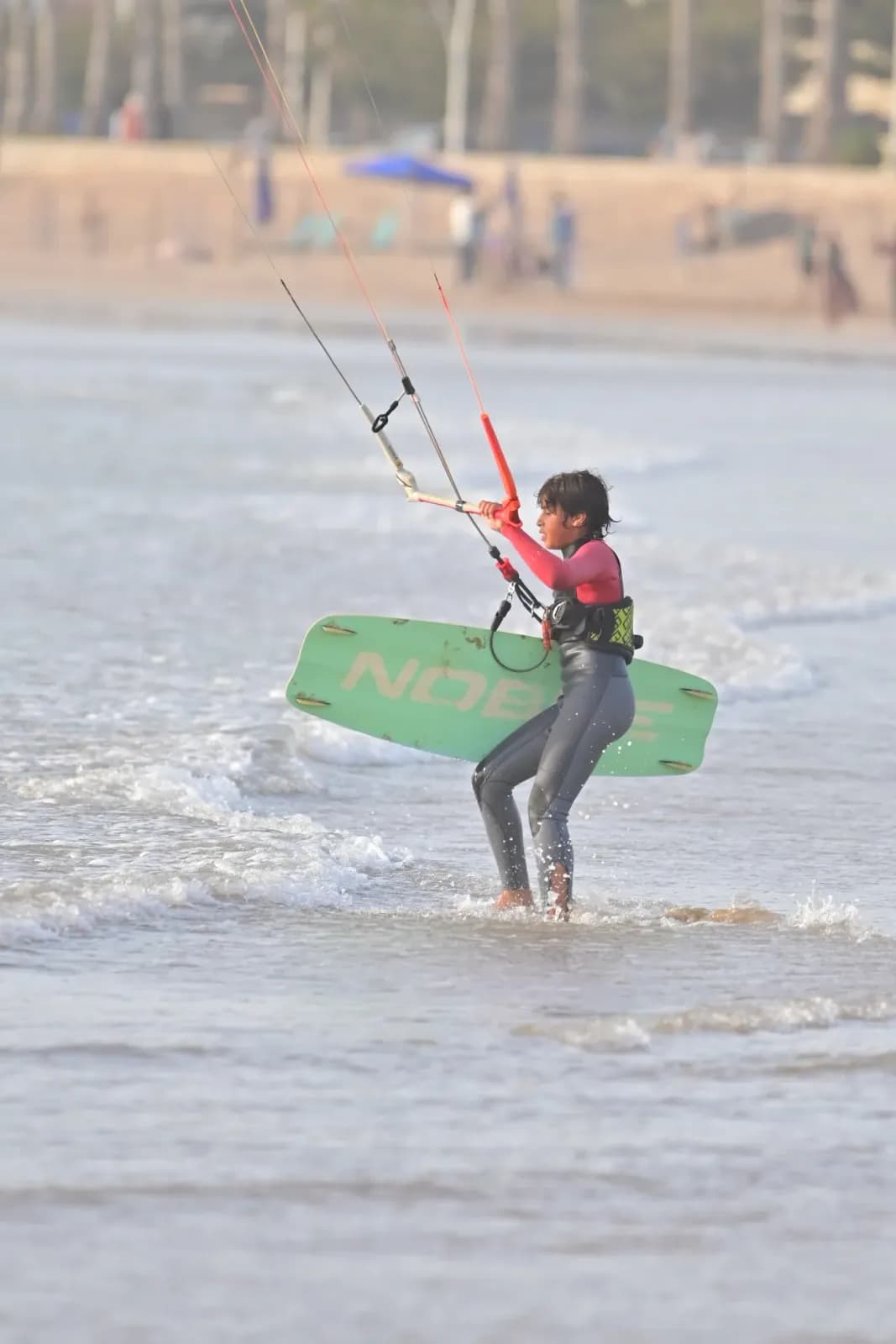Jeune élève en cours de kitesurf à Essaouira, planche aux pieds dans les vagues — école Windy Essaouira