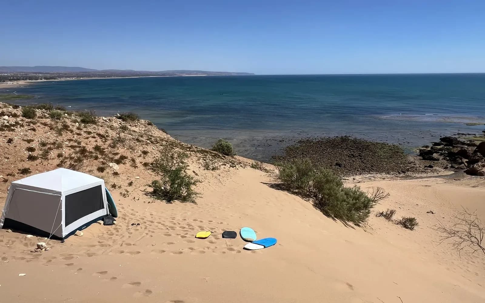 Les dunes d'Ouassane face à l'Atlantique, planches de sandboard posées sur le sable au pied de la pente