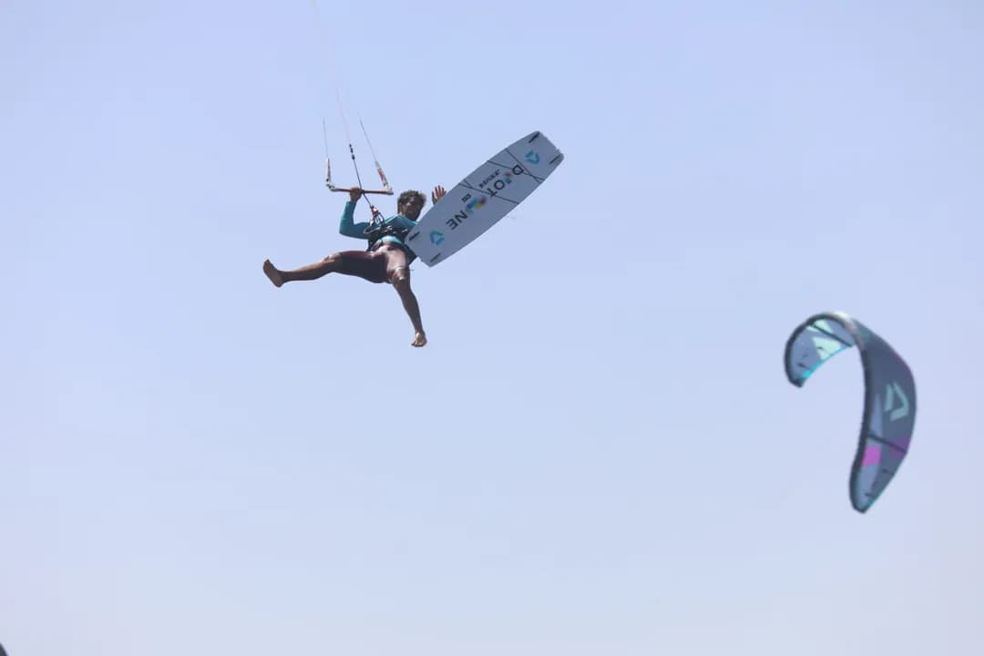 Saut freestyle en kitesurf à Essaouira — rider en grab au-dessus de l'eau avec Windy Essaouira