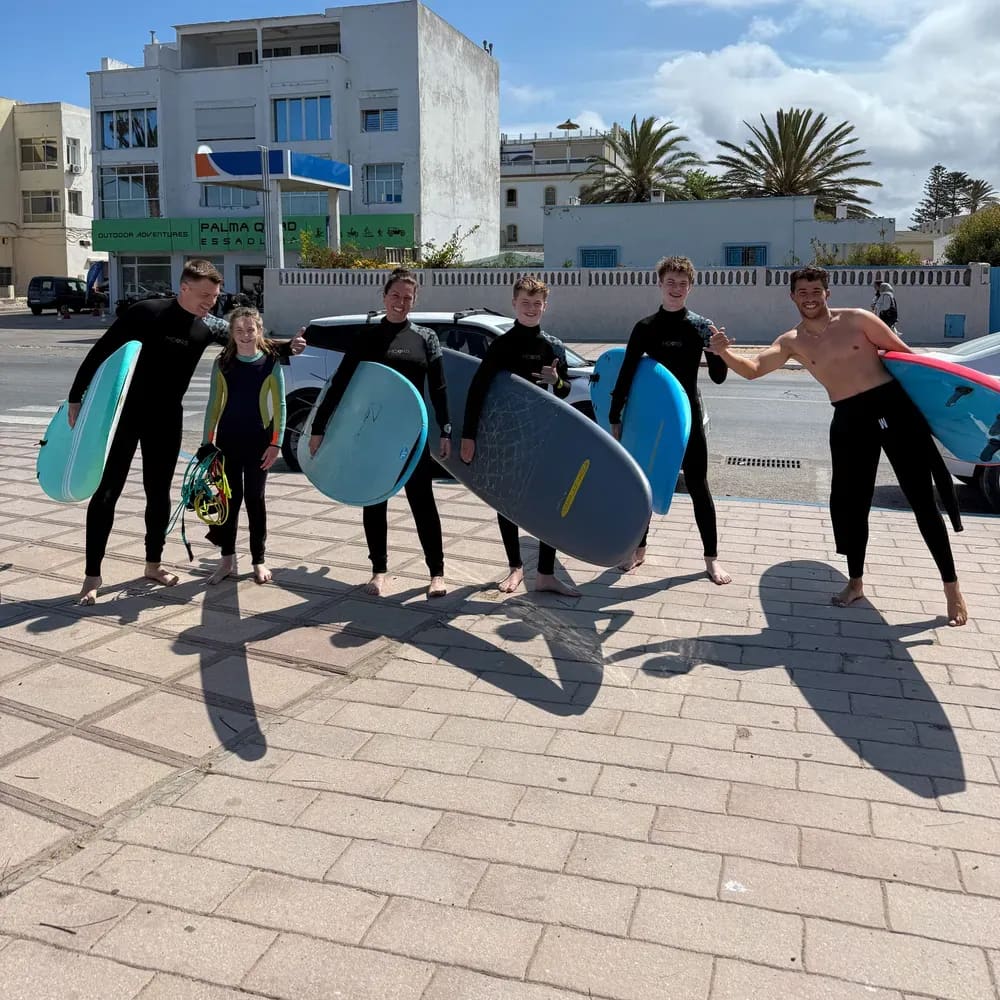 Groupe d'élèves avec leurs planches de surf en mousse près de la plage d'Essaouira, école Windy Essaouira