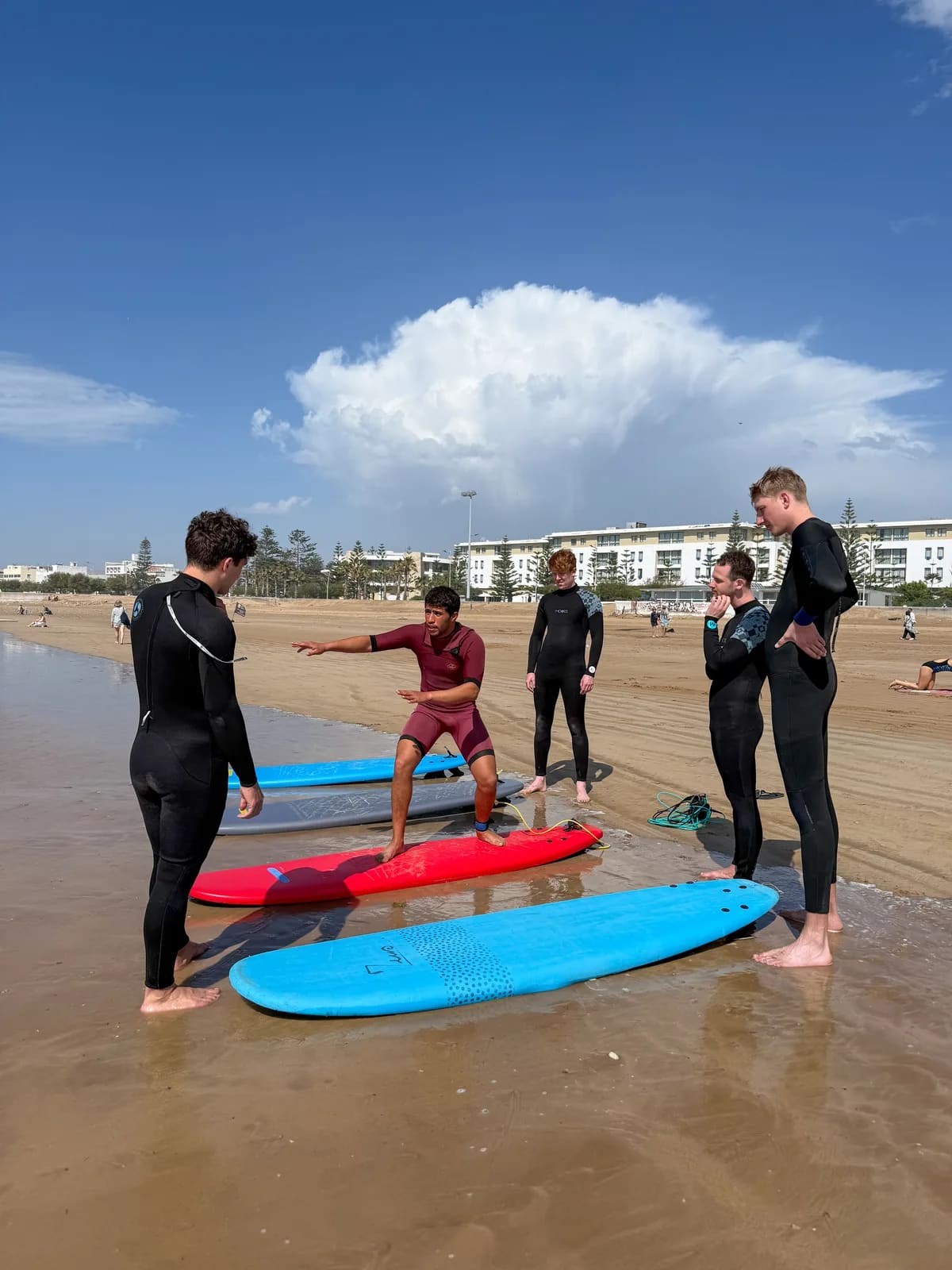Cours de surf à Essaouira — moniteur démontre le pop-up à un groupe sur la plage, école Windy Essaouira